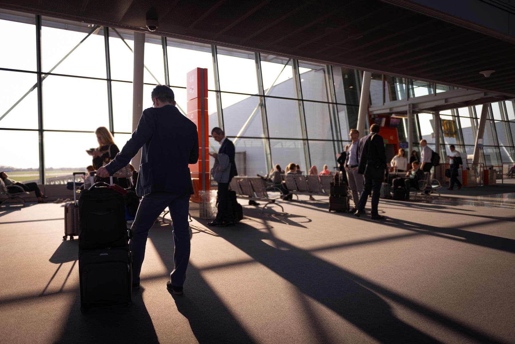 Travellers moving through a busy international airport terminal